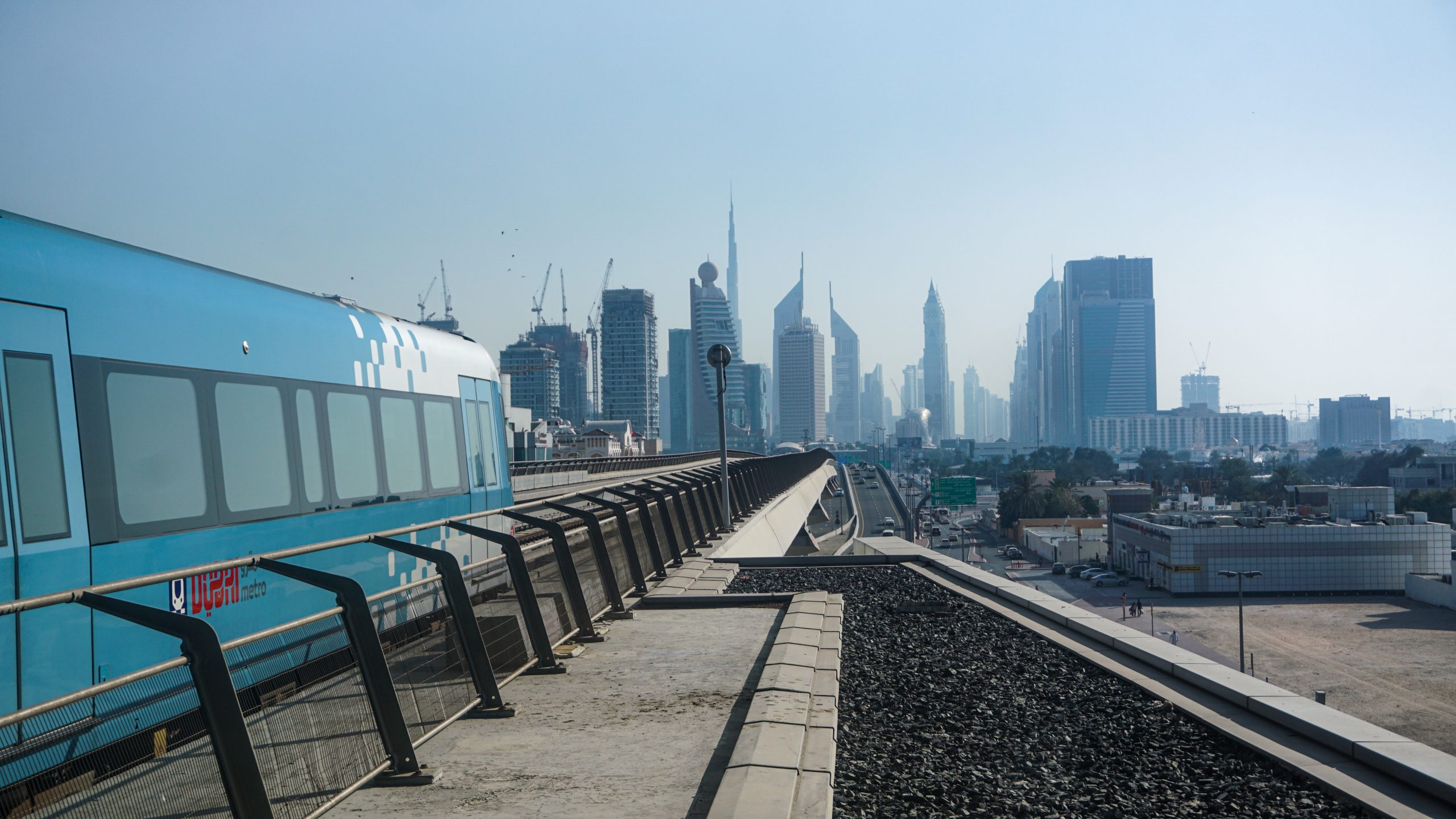 A metro train leaving the metro station and is heading towards downtown Dubai