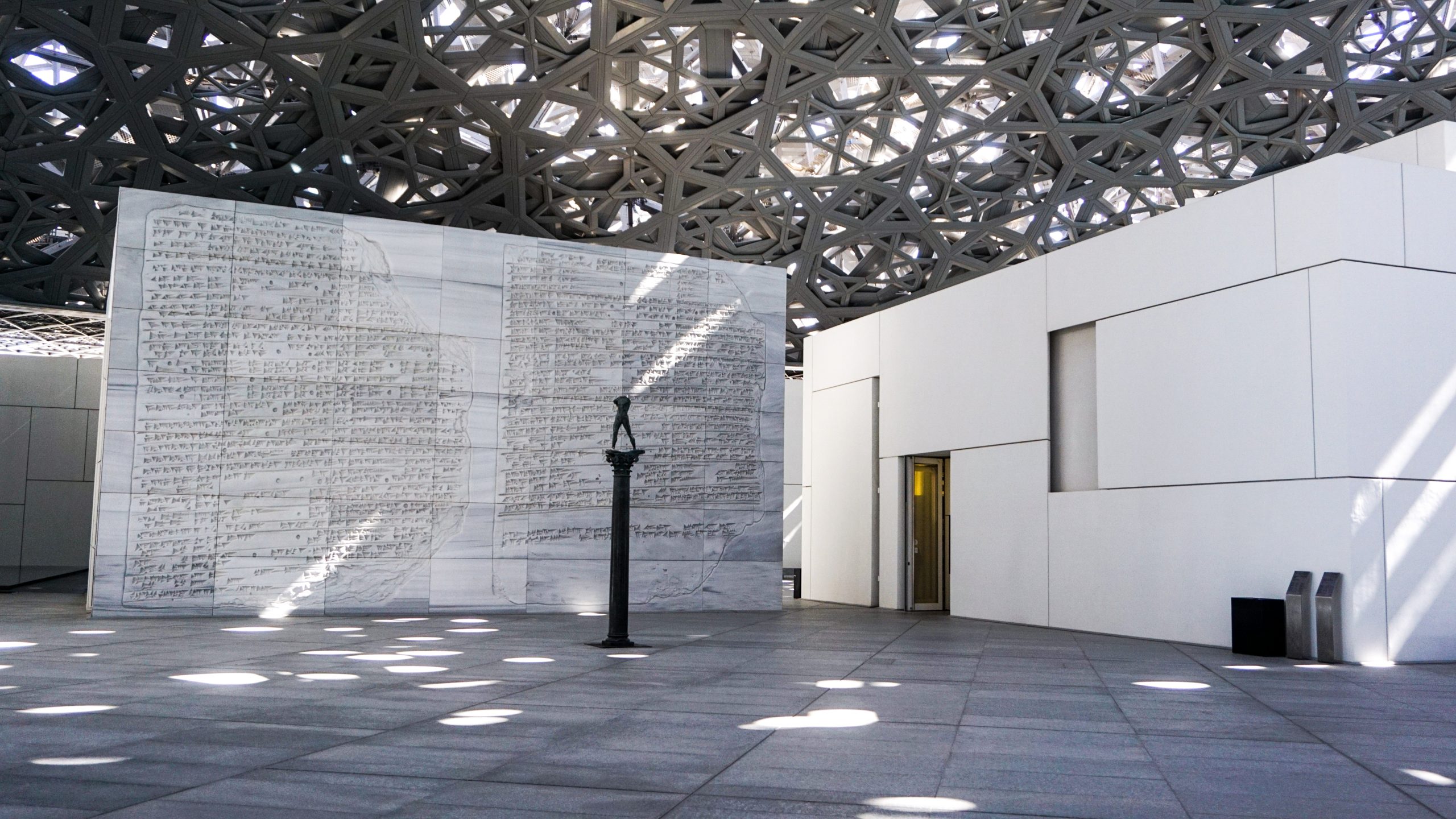 The outdoor spaces of the Louvre Abu Dhabi with a statue in the middle from Dubai Itinerary Day 6