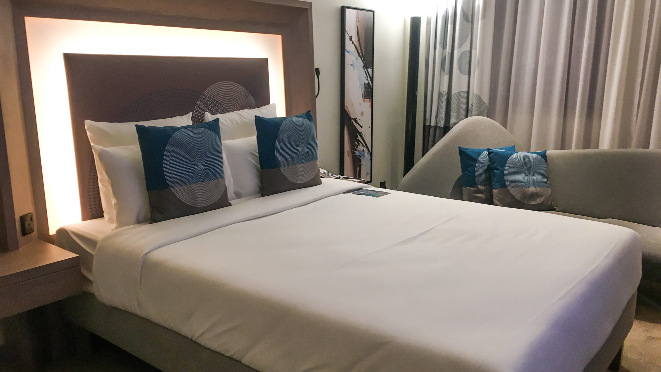 A double bed and a sofa at Novotel Bur Dubai