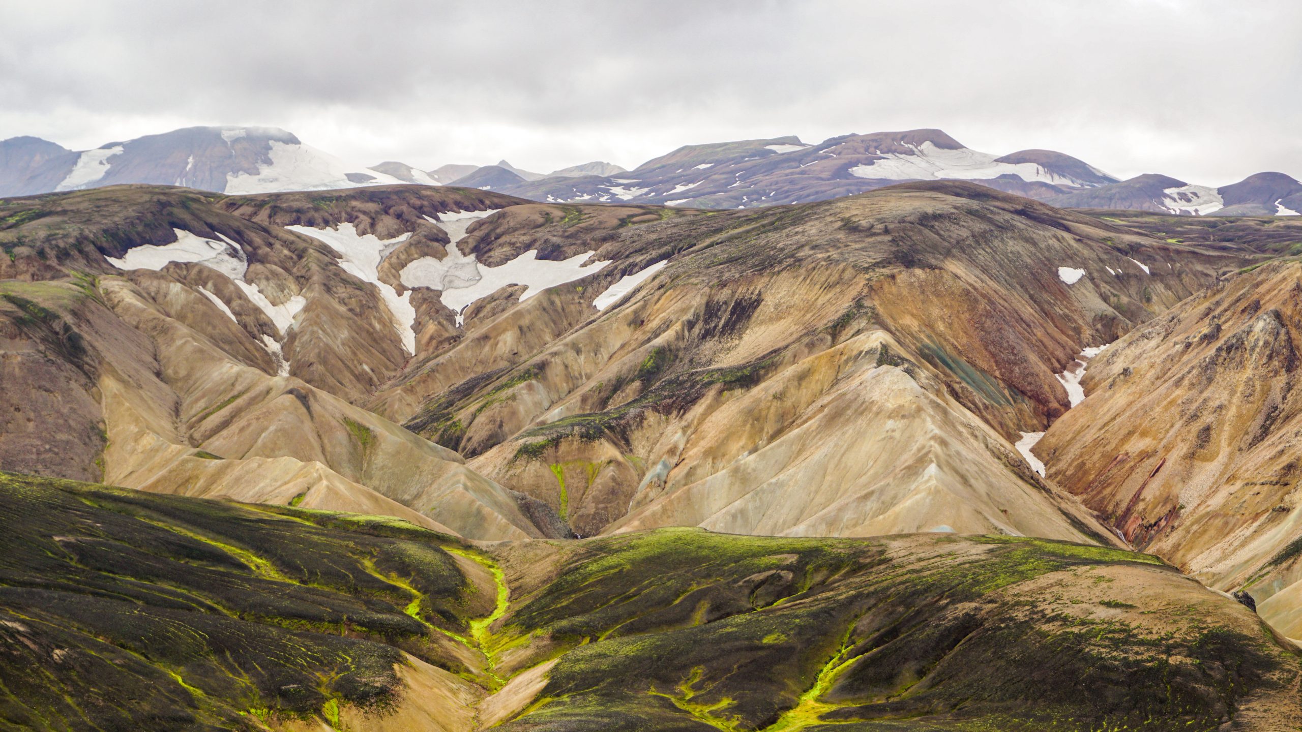 Views of orange and green mountains with glacier at the back in Landmannalaugar