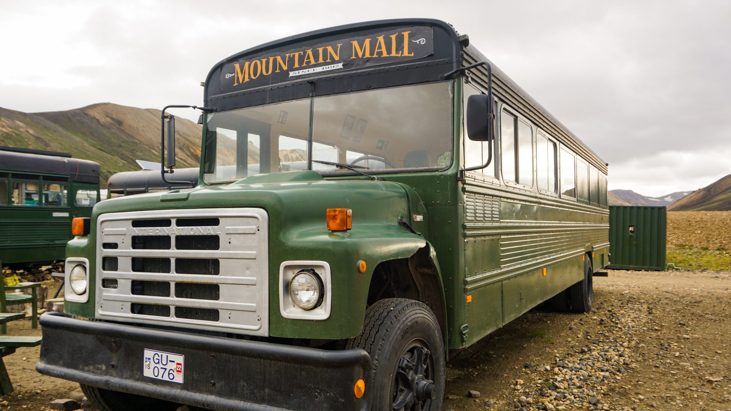 A green old bus with the sign "Mountain Mall"
