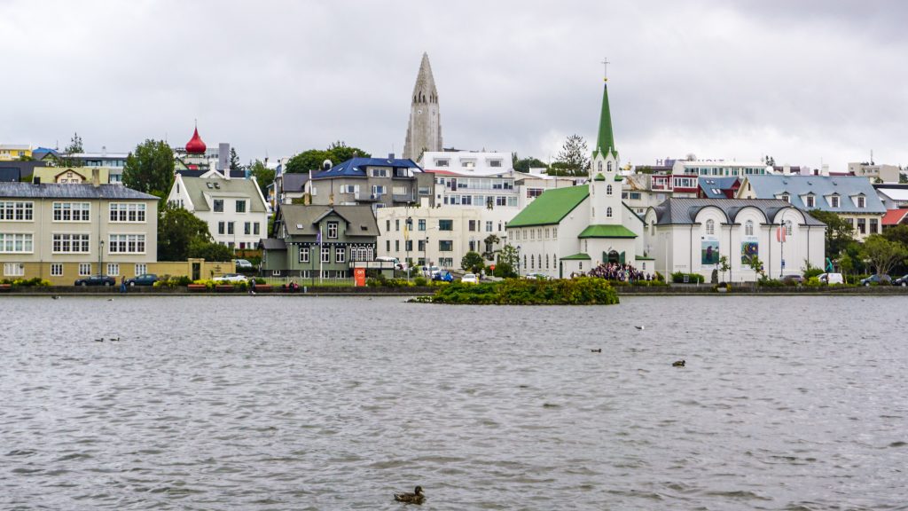 Cityscape of Reykjavik with a river, a church and some houses in view for Iceland itineraries