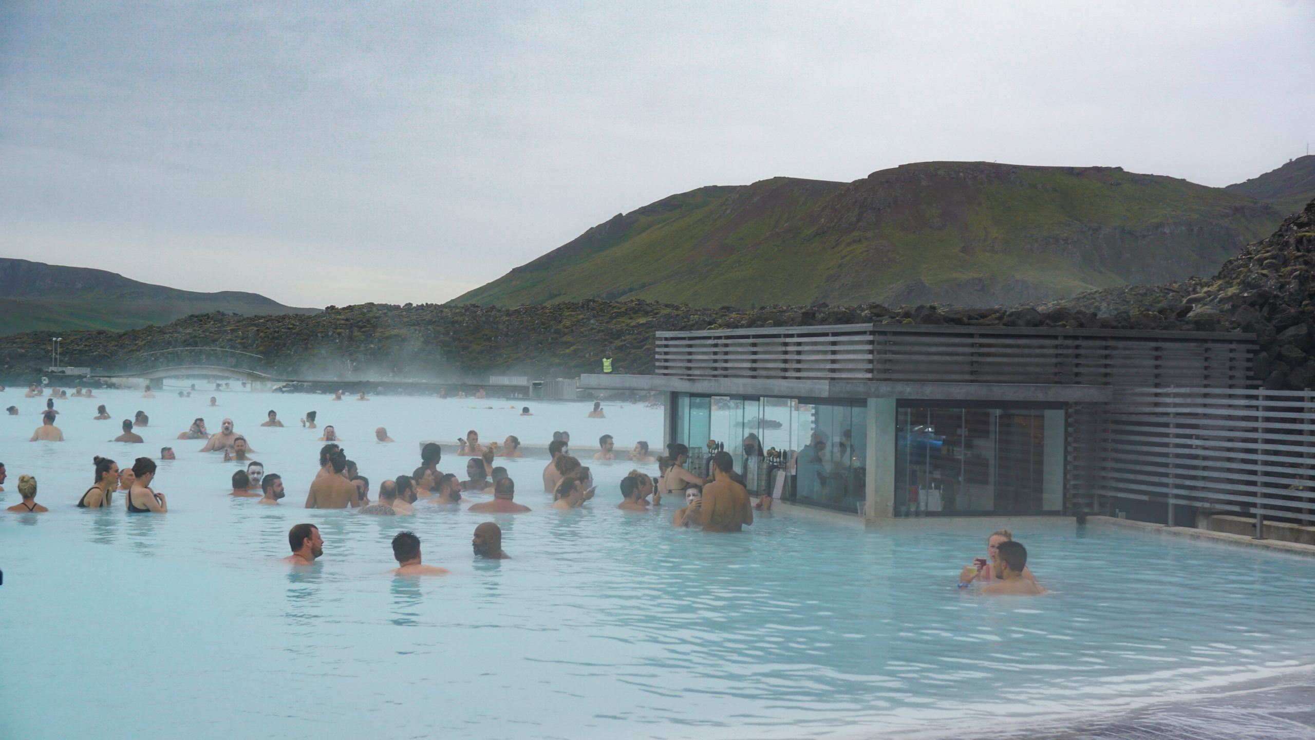 People relaxing with a drink and a mud mask at the Blue Lagoon