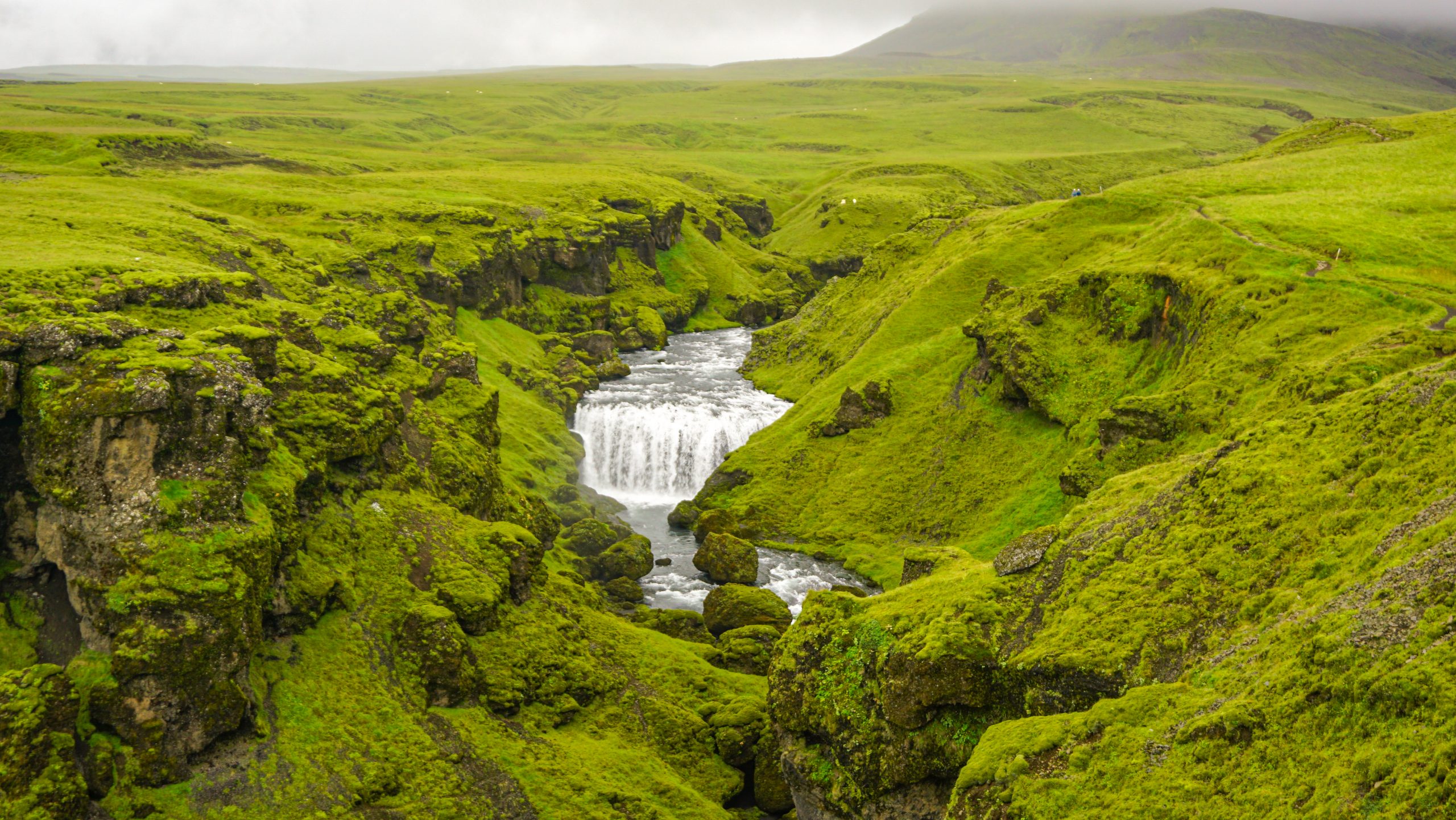 A waterfall next to a hiking path in Iceland